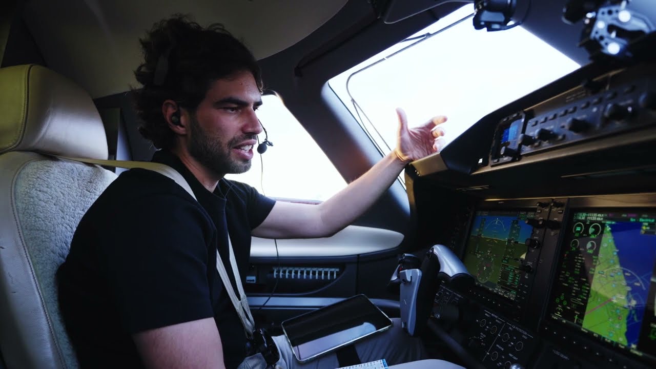 Pilot reviewing the Garmin Prodigy cockpit of a Phenom 100